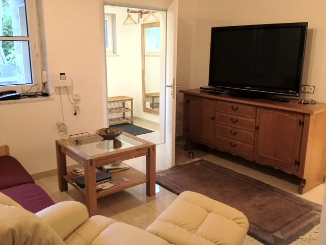 Wohnzimmer mit Flachbildfernseher und gemütlicher Sitzecke