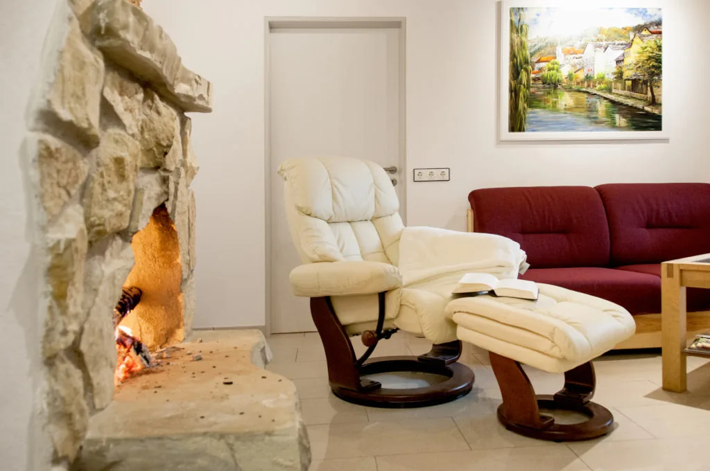 Offener Echtholz-Kamin mit Sessel im Wohnbereich